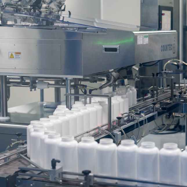 Medicine bottles moving down a production line in a manufacturing facility