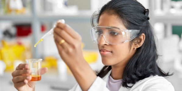 Laboratory worker measuring liquid in beaker