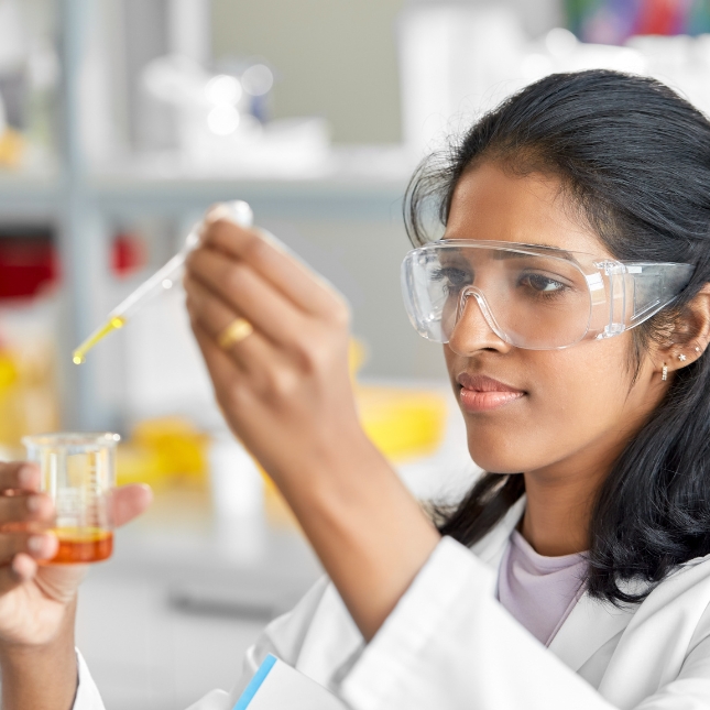 Laboratory worker measuring liquid in beaker