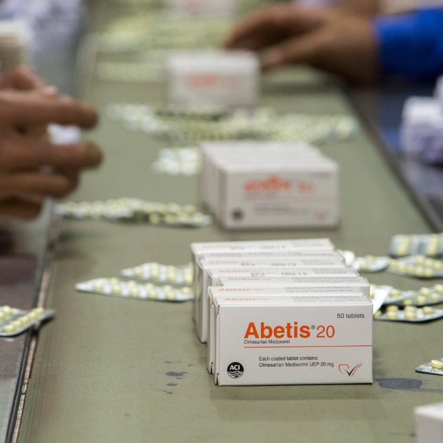 Medicines moving down a conveyor belt in a manufacturing facility