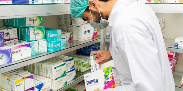 Pharmacist in Pakistan stocking shelves with medicines