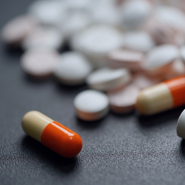 Red and white pills and tablets on a black background